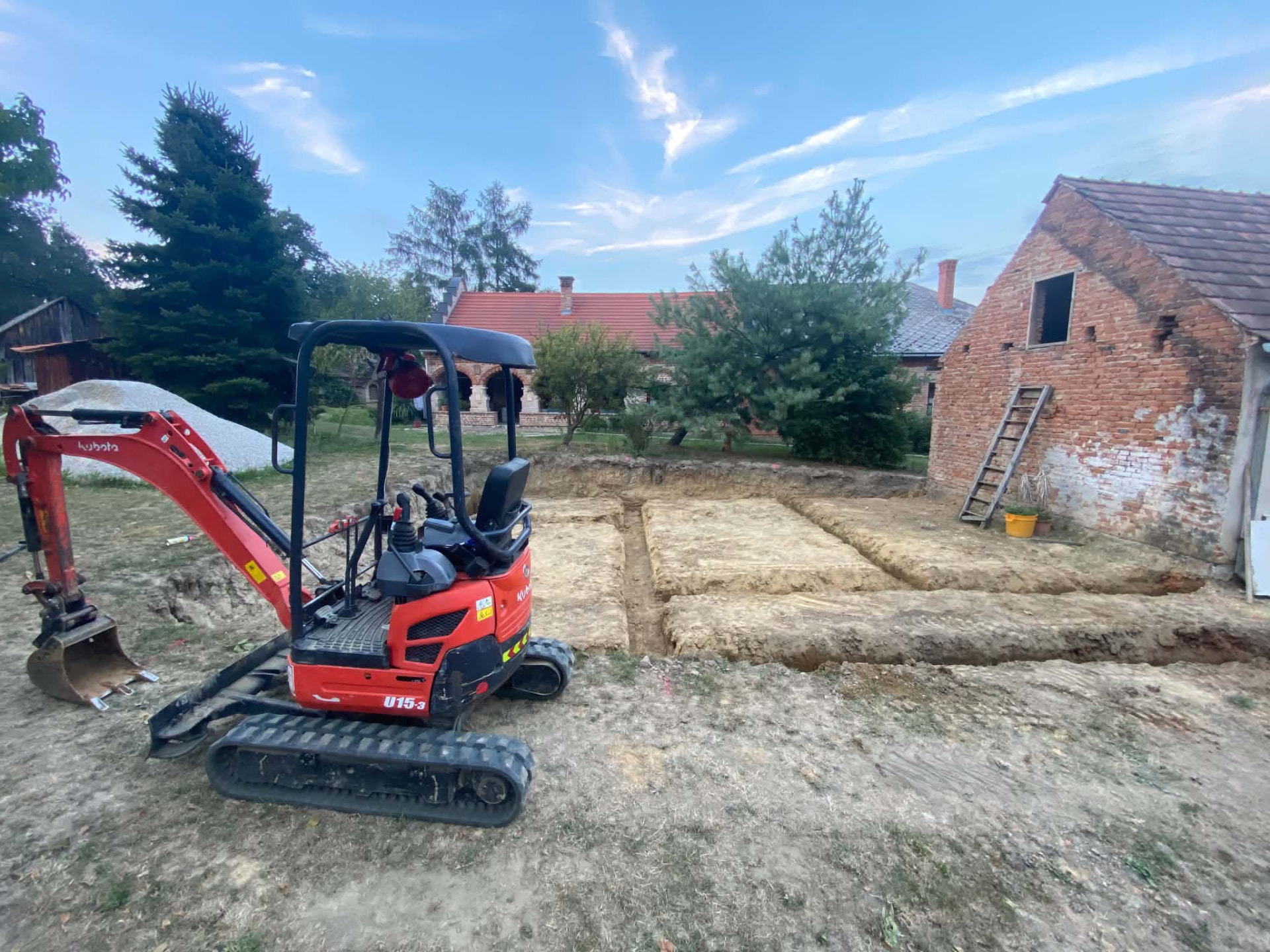 Alapásás minikotróval régi ház mellett